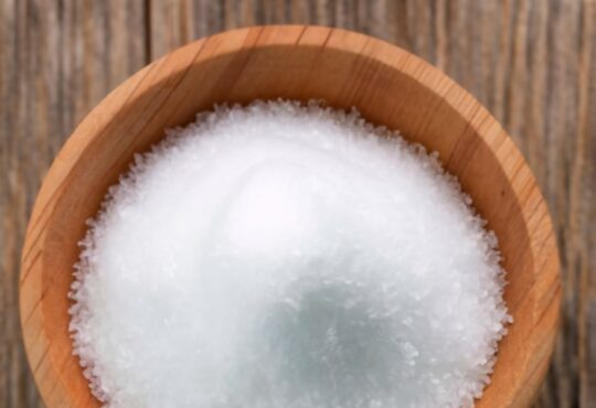white chloride grains, resting on wooden table