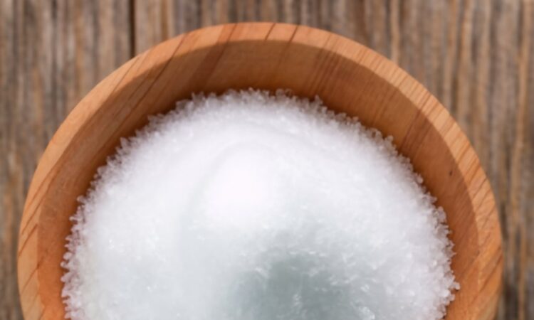 white chloride grains, resting on wooden table